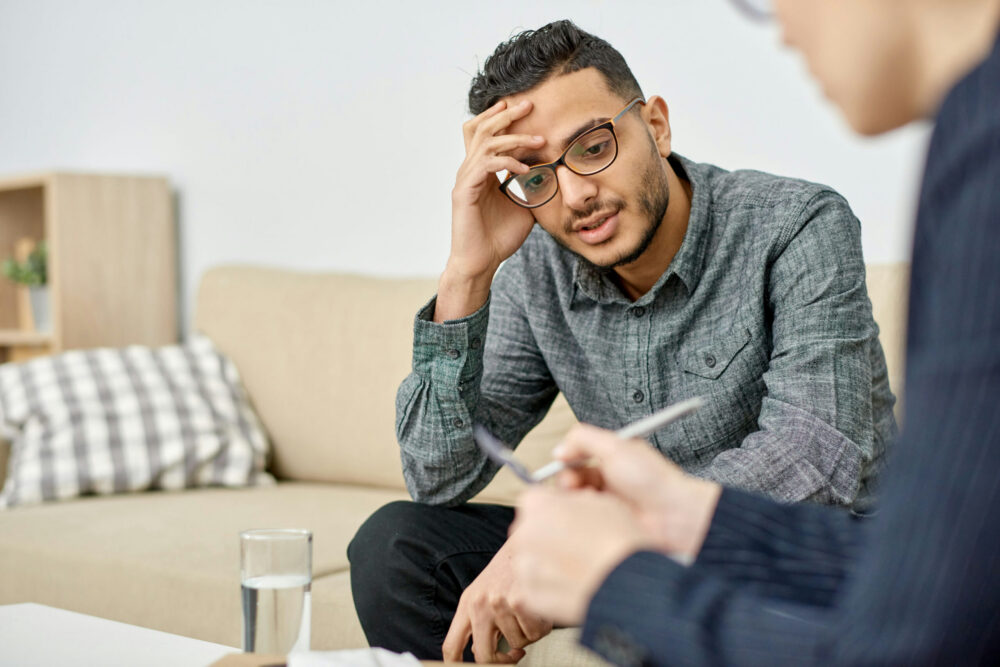 A male client speaking with a recovery coach during a one-on-one counseling session