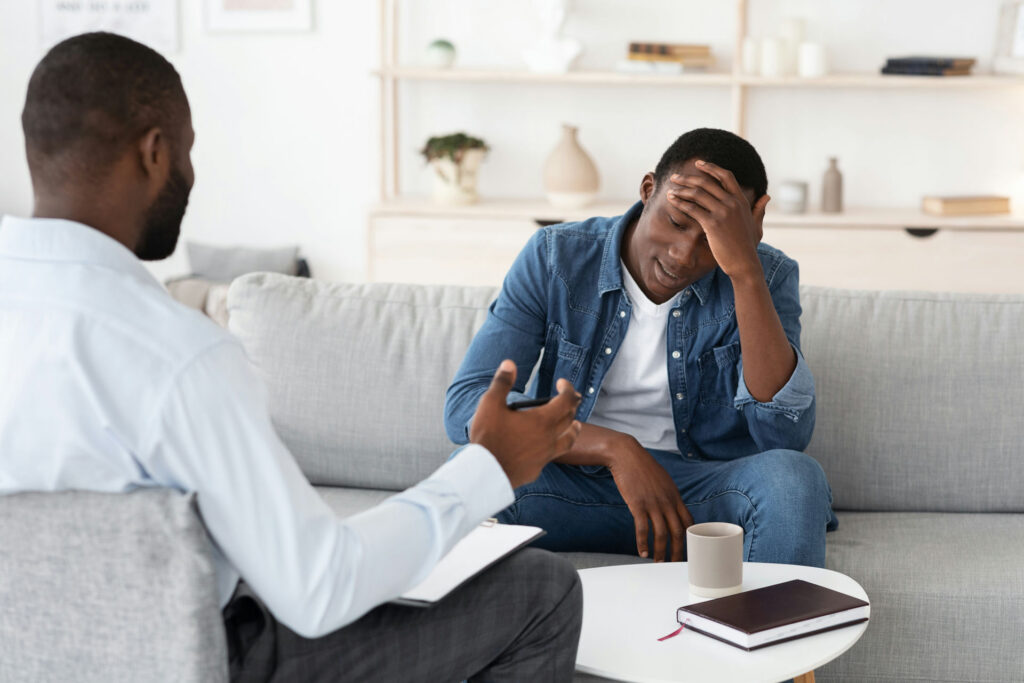 a man with hand on head in therapy